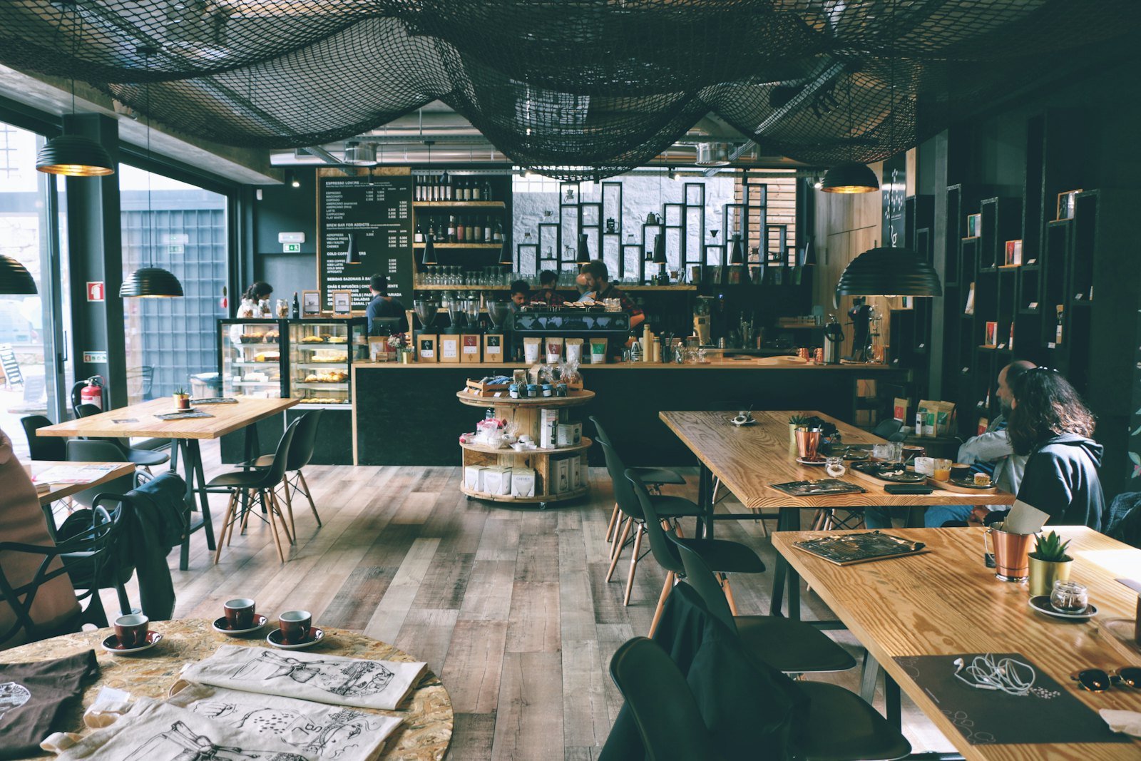 Two people sitting across a table in a cafe, cinematic vibe
